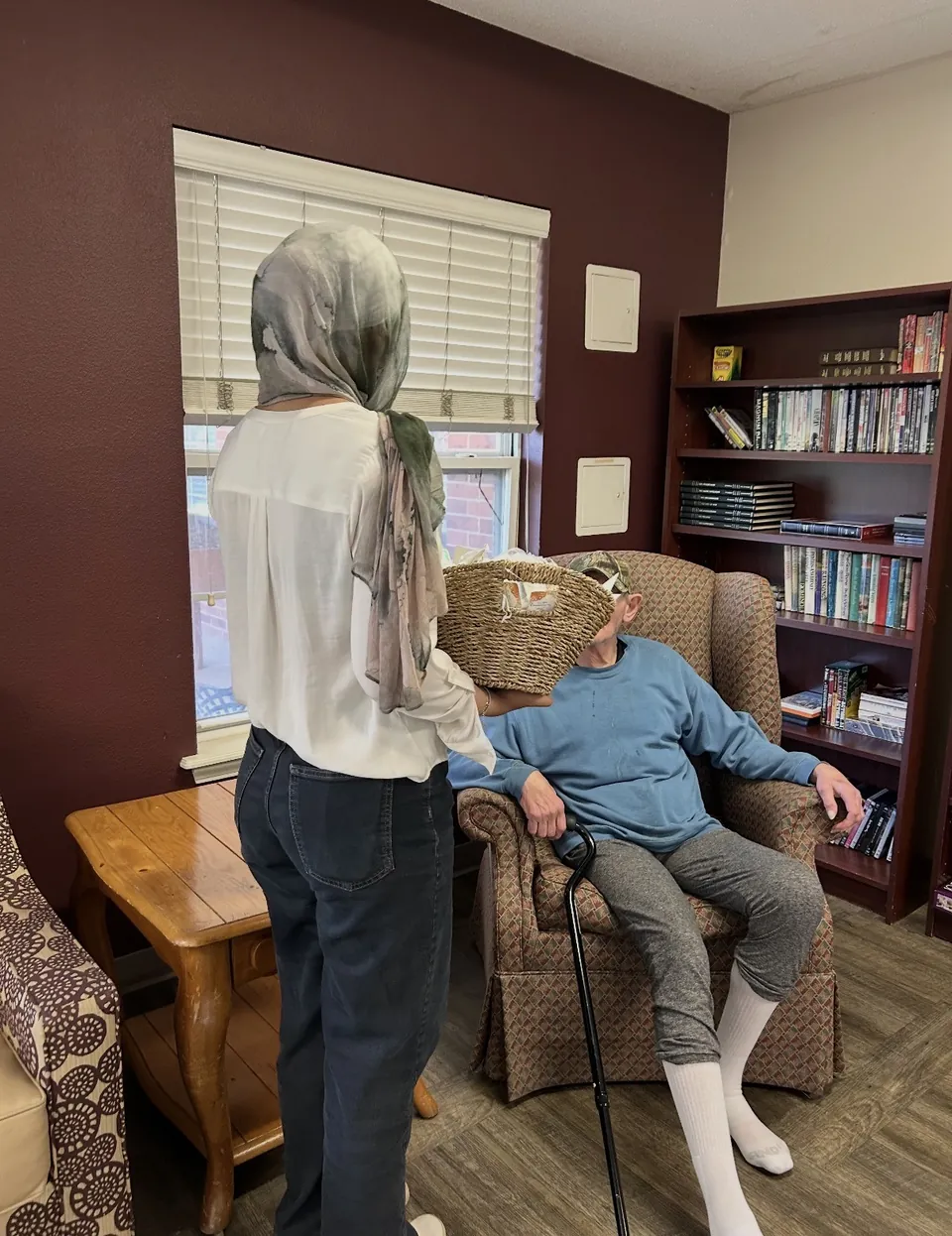 A One Good Cookie member bringing a basket of prepared items to a nursing-home resident.